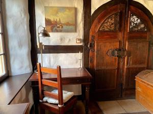 a room with a desk and a wooden door at Ferienhaus Waffenkammer mit 3 Schlafräumen in Leppersdorf