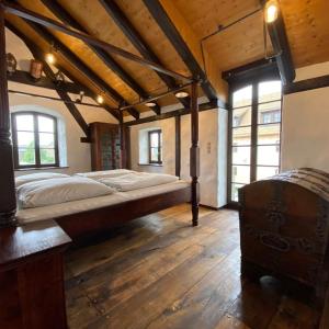 a bedroom with a large bed in a room with wooden floors at Ferienhaus Waffenkammer für 7 Personen in Leppersdorf