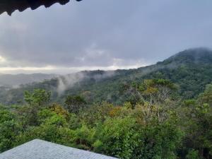 a view of a mountain with clouds in the trees at Mandalas Ecolodge in Cerro Azul