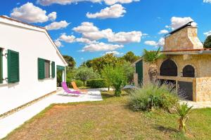 una casa con un patio con sillas y un edificio en Ferienhaus für 6 Personen ca 50 qm in Ližnjan, Istrien Südküste von Istrien, en Ližnjan