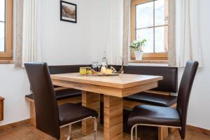 a dining room with a wooden table and chairs at Neue Ferienwohnung in Mittersill mit Grill und Garten in Hollersbach im Pinzgau