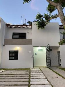 莫雷洛斯港的住宿－La Casa del Arbol -4bed 3 bath，白色的房子,有一扇门和一棵树