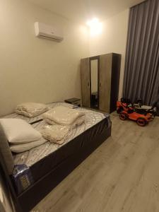 1 dormitorio con 1 cama y un coche de juguete en el suelo en Villa rotana airport road, en Al Qasţal