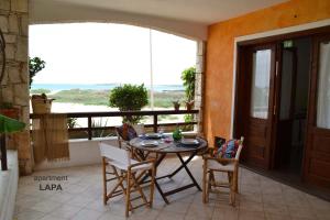 a room with a table and chairs and a balcony at BookingBoavista - Apartments in Sal Rei