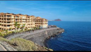 a building on a cliff next to the ocean at Heart and Soul Apartment in San Miguel de Abona