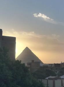 einen Blick auf die Pyramiden von Giza bei Sonnenuntergang in der Unterkunft Nana Pyramids Guest House in Kairo