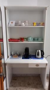 a white cabinet filled with bowls and dishes at Matrimoniale francese con bagno privato in Noicattaro
