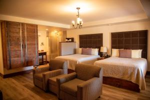 een hotelkamer met 2 bedden en een stoel bij Hotel Hacienda Santana in Tecate
