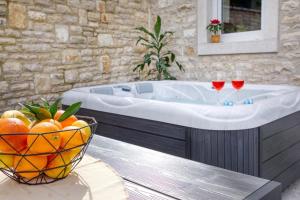 a bathroom with a tub with a bowl of oranges at Ferienhaus für 6 Personen ca 86 qm in Peroj, Istrien Istrische Riviera in Peroj