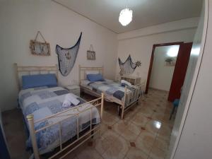 sypialnia z 2 łóżkami i lustrem w obiekcie rossy guest house w mieście Isola delle Femmine