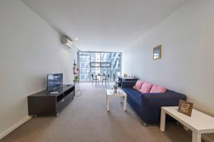 salon z niebieską kanapą i telewizorem w obiekcie Docklands Convenient & Modern 1 Bed Apartment w Melbourne
