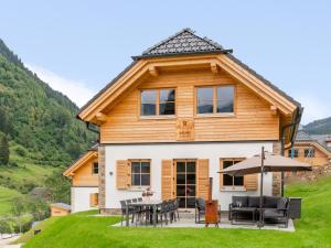 Cette maison en bois dispose d'une terrasse et d'un parasol. dans l'établissement Riesner Alpenlodge, à Donnersbachwald