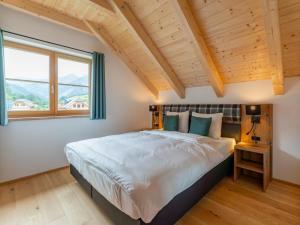 - une chambre avec un grand lit et une grande fenêtre dans l'établissement Riesner Alpenlodge, à Donnersbachwald