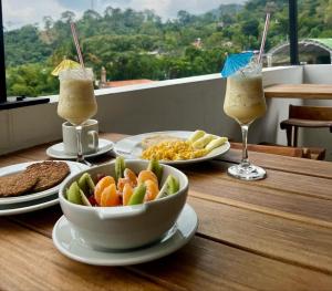 a table with plates of food and two glasses of juice at VILLA DEL ROSARIO in Tena