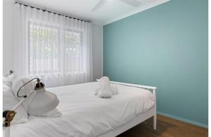 a white bed in a room with a window at Light filled Villa- Moments to the Beach in Blue Bay 