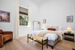 1 dormitorio blanco con 2 camas y sofá en Cozy North Melbourne Family Retreat, en Melbourne