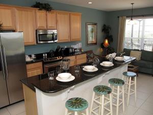 una cocina con una gran isla con taburetes de bar en Archfeld Villa 2568 en Orlando