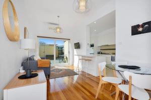 sala de estar y cocina con mesa y sillas en Yarraville - Modern Historic Home en Yarraville