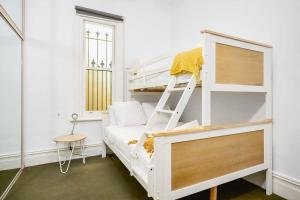 Litera blanca con escalera en una habitación en Yarraville - Modern Historic Home en Yarraville