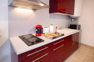 a small kitchen with a stove and a sink at LD - location Montluçon in Montluçon