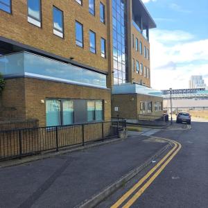 an empty street in front of a large brick building at Paradise - Away - From - Home in Bracknell