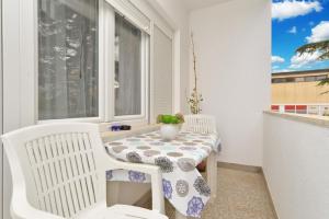 una mesa y sillas en un balcón con ventana en Ferienwohnung für 4 Personen ca 40 qm in Fažana, Istrien Istrische Riviera - b43347, en Fažana