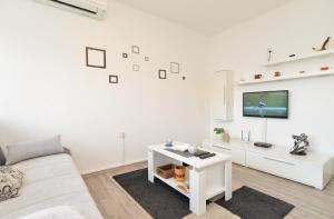 sala de estar blanca con sofá y TV en Ferienwohnung für 4 Personen ca 40 qm in Fažana, Istrien Istrische Riviera - b43347, en Fažana