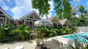 a house with a swimming pool in front of it at Love Coconut Bungalow in Gili Trawangan
