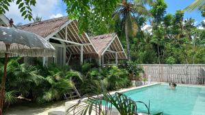 a swimming pool in front of a house at Love Coconut Bungalow in Gili Trawangan