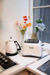 a white toaster sitting on a kitchen counter with flowers at Vintage Charm in the Heart of Sydney CBD close to the Opera House in Sydney
