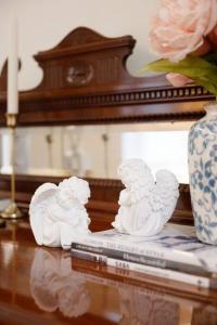 two white statues on a table with a vase of flowers at Vintage Charm in the Heart of Sydney CBD close to the Opera House in Sydney