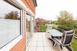 a patio with a table and chairs on a balcony at Ferienwohnung-4-mit-Sonnenbalkon-im-Landhaus-Hubertus-Duhnen in Cuxhaven