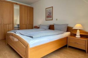 1 dormitorio con 1 cama grande con marco de madera en Ferienwohnung-4-mit-Sonnenbalkon-im-Landhaus-Hubertus-Duhnen, en Cuxhaven