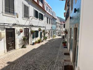 an empty street in an alley with buildings at Apartamento Brisa do Mar in Sesimbra