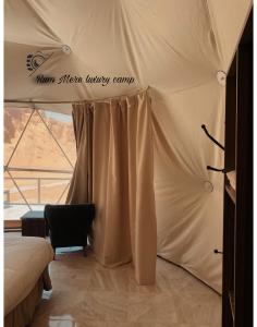 a tent with a bed in a room with a window at Rum Mere luxury camp in Wadi Rum