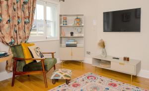 uma sala de estar com uma cadeira e uma televisão em Prime Central London Apartment - Covent Garden em Londres