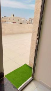 a window with a green patch of grass on the side of a building at Amazing Rooftop for rent in Irbid in Irbid
