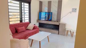 a living room with a red couch and a tv at Amazing Rooftop for rent in Irbid in Irbid