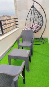 a swing and a chair on a balcony with grass at Amazing Rooftop for rent in Irbid in Irbid