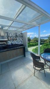 a patio with a table and chairs and a kitchen at Casa de praia in Paraty