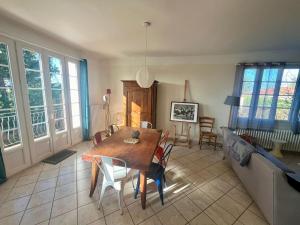 uma sala de estar com uma mesa e um sofá em MAISON FLEURS - 5min de Vichy - Jardin - Calme em Creuzier-le-Vieux