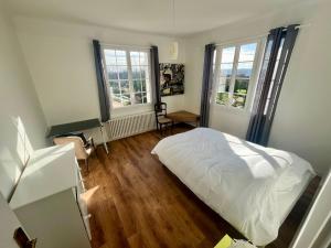 um quarto com uma cama branca e 2 janelas em MAISON FLEURS - 5min de Vichy - Jardin - Calme em Creuzier-le-Vieux