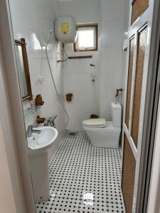 uma pequena casa de banho com lavatório e WC em White's house em Quan Lạn