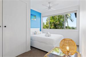 1 dormitorio con ventana, 1 cama y 1 silla en Holiday Home with Ocean Views Wamberal, en Wamberal
