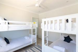 two bunk beds in a room with white at Casa Bel - Pool Table-Minutes From Beach in Middle Camp
