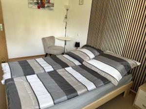 a bedroom with a large bed with a chair and a lamp at Lussen in Regen