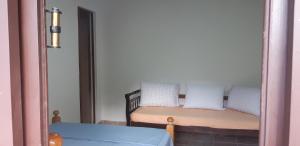 Dormitorio pequeño con cama y espejo en Ponta Negra Hospedagem en Maricá