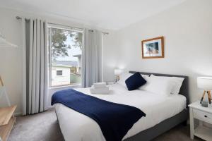 a bedroom with a large bed and a window at Lake Front Home - Relax & Unwind in Budgewoi