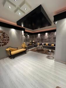 Cette grande chambre comprend une scène avec un canapé et des chaises. dans l'établissement شقة غرفتين وصاله بتصميم مودرن, à Riyad