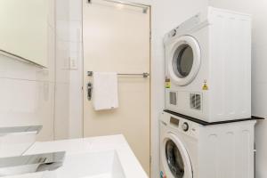 a bathroom with a washing machine and a sink at Beachside Living in Modern 2 bedroom Apartment in Sydney